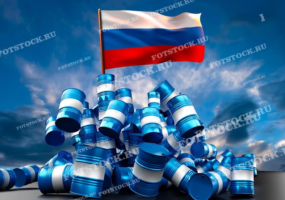 На фотографии изображены нефтяные бочки, сложенные в горку, на вершине которой развевается флаг России. Изображение символизирует важность нефтяной промышленности для страны и подчеркивает национальную идентичность и ресурсы.